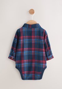 Pluszowy kombinezon w kratę w kolorach granatowym, czerwonym i niebieskim, z kołnierzykiem i podwijanymi rękawami, zapinany na zatrzaski u dołu dla łatwego ubierania.