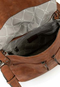 Sac à main en cuir marron ouvert montrant l’intérieur en tissu gris avec une doublure à motifs circulaires et une poche zippée.