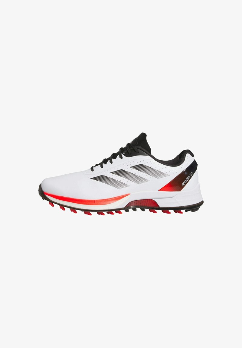 Witte sportschoenen met zwarte accenten, voorzien van drie zwarte strepen, een rode zool en een lichtgewicht ontwerp. Geribbeld bovenwerk met perforaties.