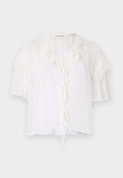 Blusa bianca a maniche corte realizzata in tessuto leggero, con dettagli a volant attorno al colletto e alle maniche. Si annoda sul davanti.