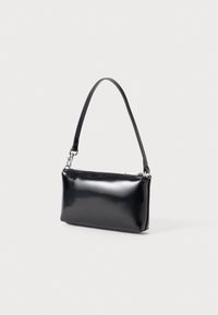 Pochette rectangulaire noire avec une seule bandoulière et une fermeture éclair en haut, présentée sur un fond clair.
