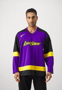 Violeta un melns garās piedurknes džersijs ar dzelteniem akcentiem, ar "LAKERSHOW" logotipu uz priekšpuses, izgatavots no elpojoša materiāla.