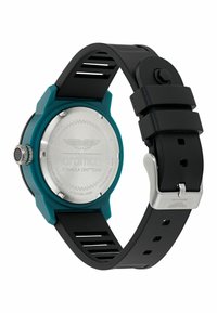 Reloj Aston Martin con fondo de acero inoxidable, bisel en color teal y correa de goma negra con recortes. Forma redonda, con una corona prominente.