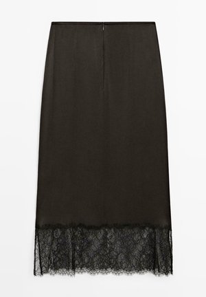 Svart pennkjol med ett slätt tyg ovanpå och spetskant vid fållen, med en dragkedja baktill för stängning.