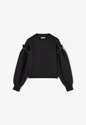 Musta pitkähihaisuus pusero, jossa on puffattuja olkapäitä, helmikoristeet hihoissa sekä ribattuja hihansuita ja pääntietä.