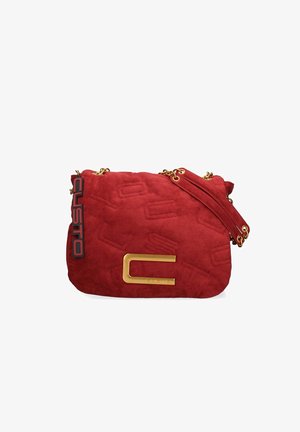 Rode suède schoudertas met gouden kettingband, geperst patroon, grote gouden "C" sluiting en zwart-rood merklabel dat aan de zijkant hangt.
