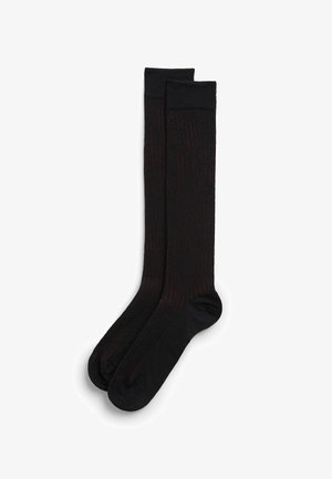 Czarne skarpetki do kolan z subtelnymi czerwonymi paskami, żebrowana struktura oraz wzmocnione obszary palców i pięt dla zwiększenia trwałości.