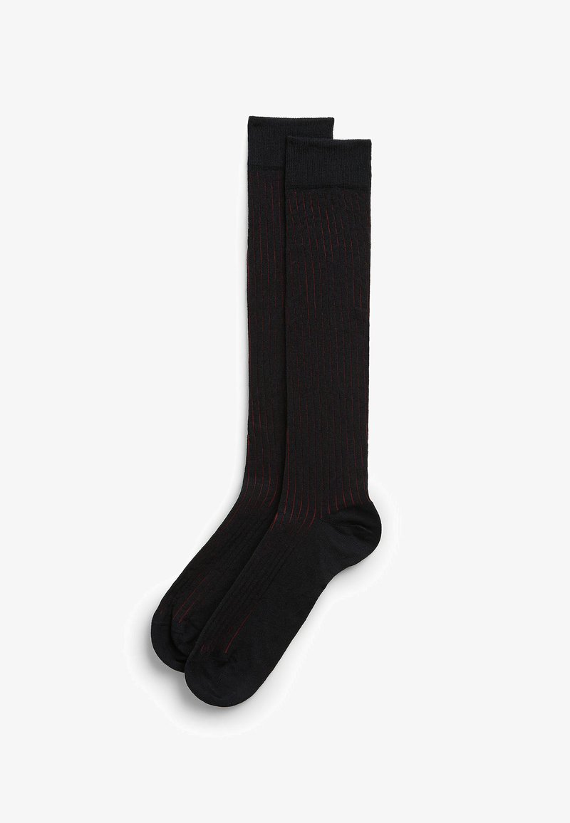 Czarne skarpetki do kolan z subtelnymi czerwonymi paskami, żebrowana struktura oraz wzmocnione obszary palców i pięt dla zwiększenia trwałości.