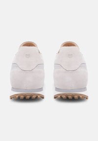 Hellgraue Wildleder-Sneaker mit glatter Oberfläche, ausgestattet mit einer strukturierten Fersenkappe und einer Gummisohle mit Rutschmustern. Minimalistisches Design.