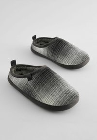 Grå og hvidternede slippers med en blød indvendig foring, en gummisål og små stropper bagpå for nem påtrækning.