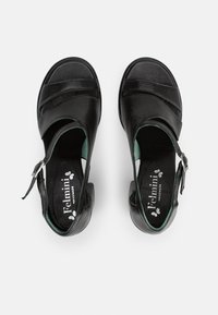 Zwarte leren sandalen met een open ontwerp, featuring diagonale banden en een zijsnubbel. Groene accenten aan de binnenkant en een lage hak.