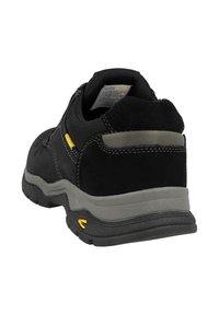 Schwarzer Wildleder- und Netzschuh mit grauer Sohle, gelben Akzenten und einem gepolsterten Schaft. Verfügt über Nähte und eine strukturierte Oberfläche.