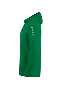Giacca leggera verde con cappuccio, texture liscia, con logo sulla spalla e dettagli decorativi a pois in grigio chiaro.