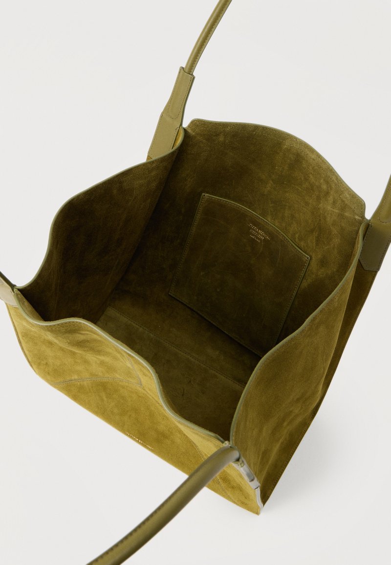 Olive green suede tote bag with two leather shoulder straps and an interior slip pocket, viewed from above showing the open main compartment.