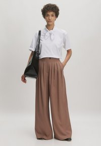 Weißes Kurzarmhemd mit Fliegenkragen, braune plissierte weite Hosen und schwarze Schultertasche. Glattes Material, bequeme Passform.