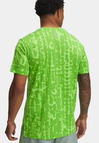 Maglietta grafica verde con un motivo astratto e texture. Maniche corte, scollo rotondo e un logo sul retro in una tonalità più chiara.