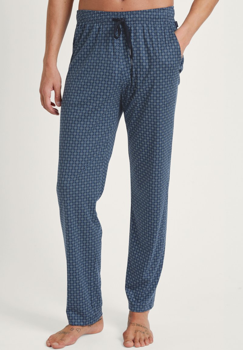 Marineblauwe pyjamabroek met een geometrisch patroon in blauw en wit, elastische tailleband met koord, zijzakken, lichte stof, relaxte pasvorm.