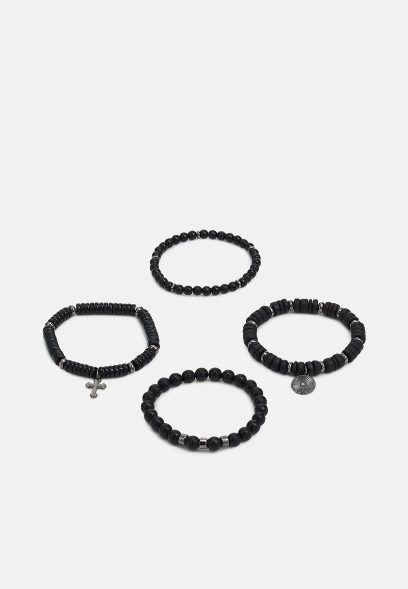 Fire sorte svarte armbånd med ulike design: ett med et korsanheng, et annet med en teksturert mønster, og runde, glatte perler på to andre.