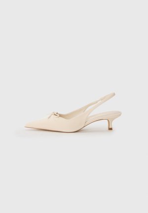 Slingback-kengät teräväkärkisellä muotoilulla, off-white nahkaa, pieni rusetti ja matala kitten-kanta. Sujuva pinta, minimalistinen muotoilu.