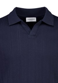 Polo bleu marine foncé avec motif zigzag vertical texturé et col ouvert, étiqueté "Lindbergh Relaxed Fit".