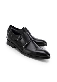 Schwarze Lederschuhe mit einem eleganten Design, spitzer Zehenform, doppelten Schnallenakzenten und einem niedrigen Absatz. Glatte Textur mit dezenten Steppnähten.