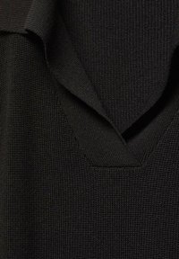 Schwarzes Stricktop mit V-Ausschnitt, strukturiertem Stoff und überlappendem Kragen, das ein glattes, gleichmäßiges Gewebe präsentiert.