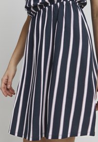 Navy blue dress with white and pink vertical stripes. Features an elastic waistband and a flared skirt, made of soft cotton material.