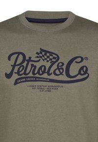 Sudadera verde oliva con un cuello acanalado, presenta un texto gráfico en azul oscuro que dice "Petrol & Co." y un diseño de bandera de cuadros.