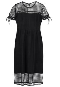 Robe noire mi-longue avec manches courtes bouffantes, détails en dentelle ajourée sur le dessus, les manches et l'ourlet, et petite fermeture bouton au niveau de l'encolure en forme de goutte.