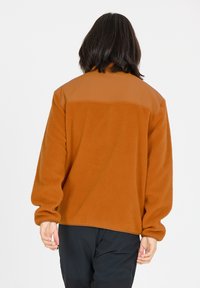 Veste en polaire marron avec un panneau supérieur lisse couleur beige, manches longues, coupe décontractée, surface texturée et ourlet droit.