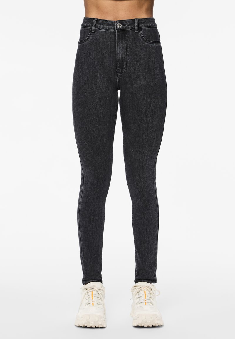 Črne skinny jeans z visokim pasom iz denima, ki imajo klasičen design s petimi žepi in sprednjim gumbom za zapiranje.