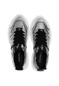 Sneaker in bianco e nero con motivo in pelle di serpente, parte superiore in rete, suola spessa bianca e lacci neri con dettagli del logo sulla lingua.