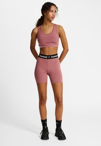 Roze sportieve crop top en bijpassende shorts met een zwarte elastische tailleband met logo tekst. Gladde stof en een slim fit ontwerp.