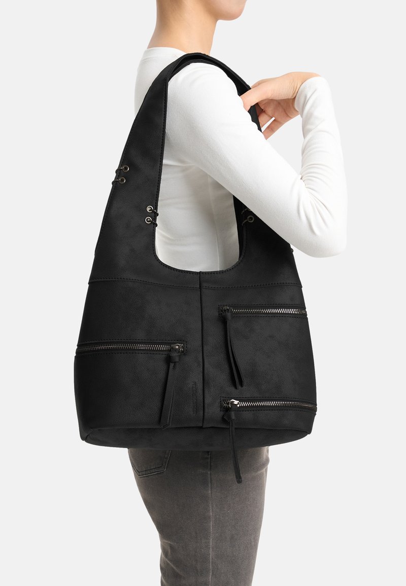 Borsa hobo in pelle nera con molteplici tasche con cerniera e dettagli con occhielli. Forma curva e texture morbida. Indossata a tracolla.