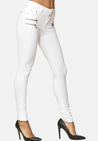 Jeans bianchi skinny realizzati in tessuto elasticizzato con una texture liscia. Presentano cerniere dorate sulle tasche e un design aderente.