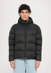 Schwarze Daunenjacke mit Kapuze, ausgestattet mit einem gesteppten Design, durchgehendem Reißverschluss und kleinem Logo auf der Brust. Glattes, leichtes Material.