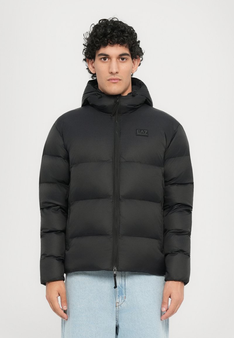 Schwarze Daunenjacke mit Kapuze, ausgestattet mit einem gesteppten Design, durchgehendem Reißverschluss und kleinem Logo auf der Brust. Glattes, leichtes Material.