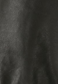 Schwarzes Ledergewebe mit einer strukturierten Oberfläche, die ein kieselartiges Finish und ein weiches, geschmeidiges Erscheinungsbild zeigt. Keine sichtbaren Muster oder Akzente.