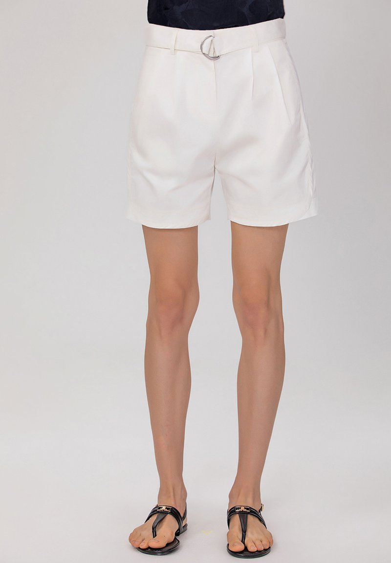 Shorts blancs plissés avec une ceinture à boucle argentée ronde. Fabriqués dans un tissu lisse, avec des poches latérales et une coupe mi-cuisse.
