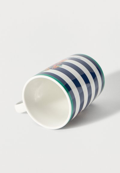 Kerámia bögre tengerészkék és fehér vízszintes csíkokkal, zöld peremmel és virágmintával, oldalt fekve egy fehér felületen.