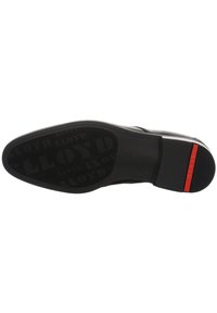 Semelle de chaussure noire en cuir avec une surface texturée ; accents rouges sur le talon ; motif de logo en relief ; bords lisses et épaisseur uniforme.