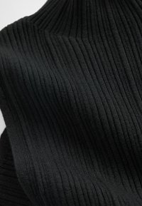 Schwarzer, gerippter Stoff mit einem Rollkragen-Design, strukturierter Oberfläche und vertikalen Linien. Weiches und dehnbares Material. Nahaufnahme.