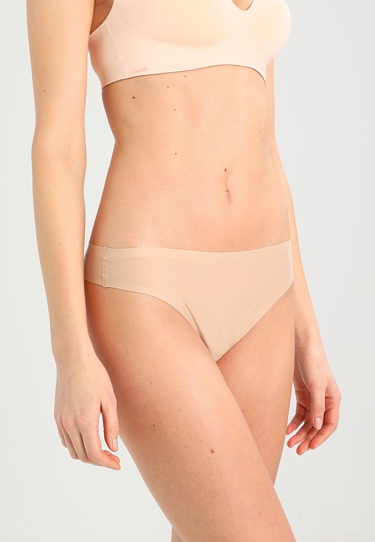 Nude kleur bikini slipjes met een gladde textuur, lage tailleontwerp en minimale bedekking. Naadloze randen en elastische tailleband.