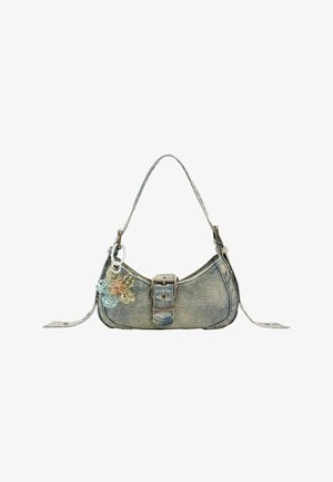 Sac bandoulière en denim avec fermeture à boucle et porte-clés fleur multicolore translucide attaché, isolé sur fond blanc.