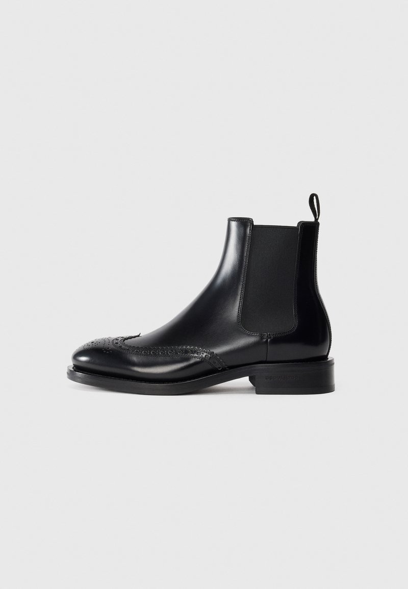 Czarne skórzane botki Chelsea z detalami w stylu brogue, gładkim wykończeniem, elastycznymi bocznymi panelami i niskim bloczkiem obcasem. Trwały i stylowy design.