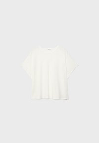 T-shirt blanc en coton à manches courtes, coupe ample, avec col rond, présenté sur un fond gris clair.