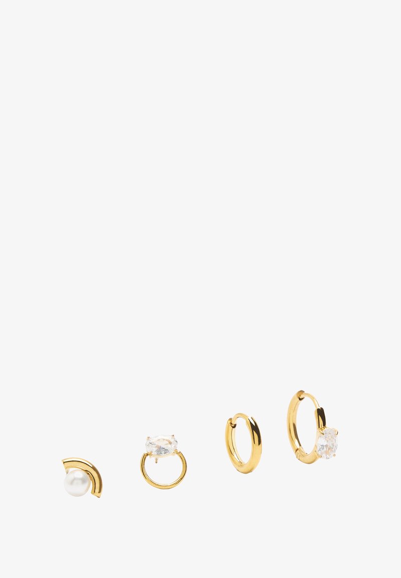 Cztery pary kolczyków: złoty metal o zakrzywionym wzorze, jeden z perłą, inny z przezroczystymi kamieniami, oraz gładka obręcz.