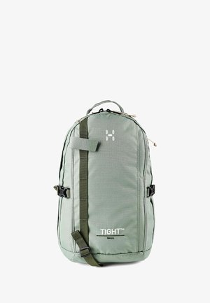 Kompakter grüner Rucksack mit vorderem Riemen, seitlichen Schnallen, Tragegriff oben und weißem "TIGHT Small"-Logo mittig vorne.