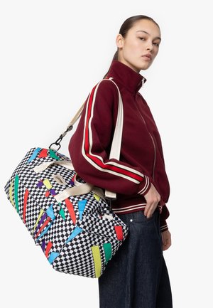 Duffle bag with a checkered pattern featuring colorful geometric shapes. Made of durable fabric, it has dual handles and an adjustable shoulder strap.