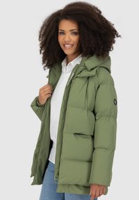 Giacca a vento verde oliva con cappuccio, chiusura a zip e dettagli elasticizzati. Presenta una texture trapuntata e tasche a toppa.